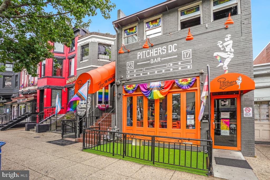 Pitchers DC bar storefront with orange awnings and colorful window decorations.