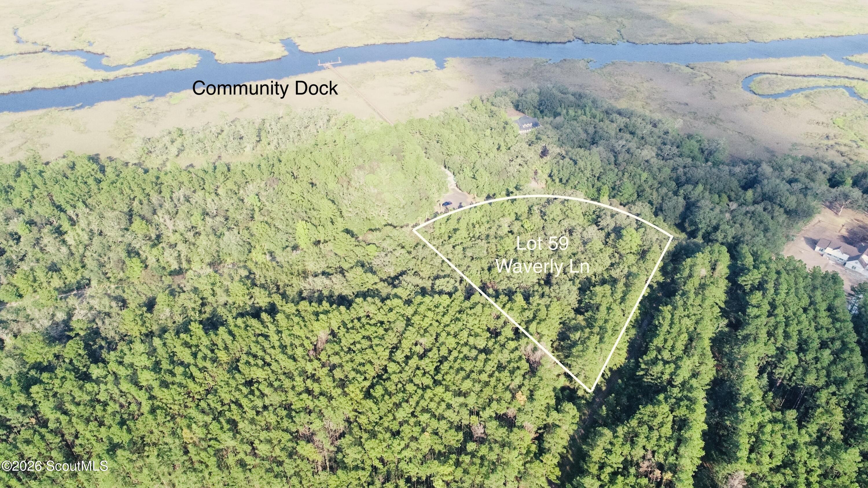 Aerial view of wooded Lot 59 on Waverly Lane, outlined near marsh waterways and a community dock.