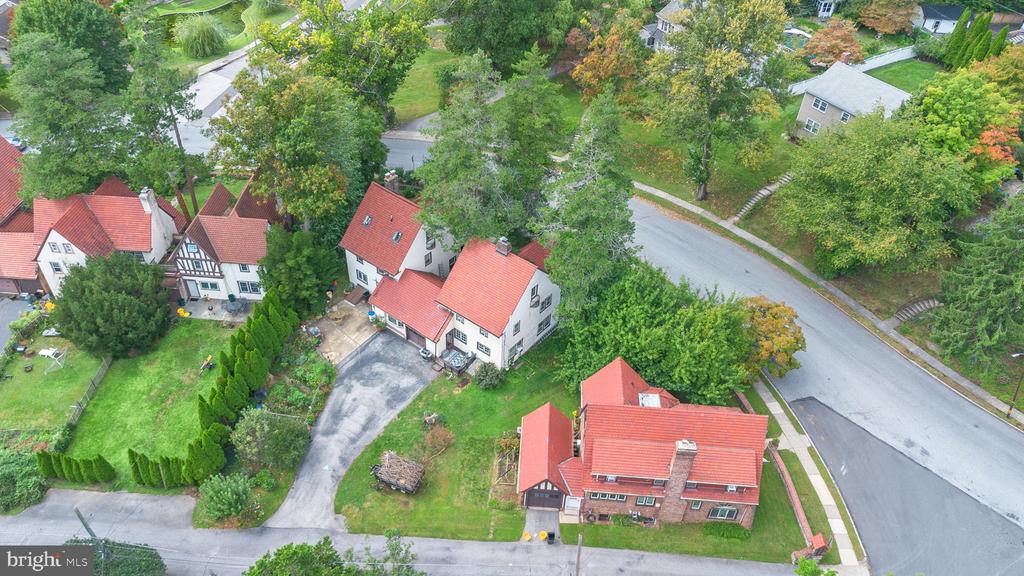 Aerial view of red-roofed homes along a tree-lined residential street.