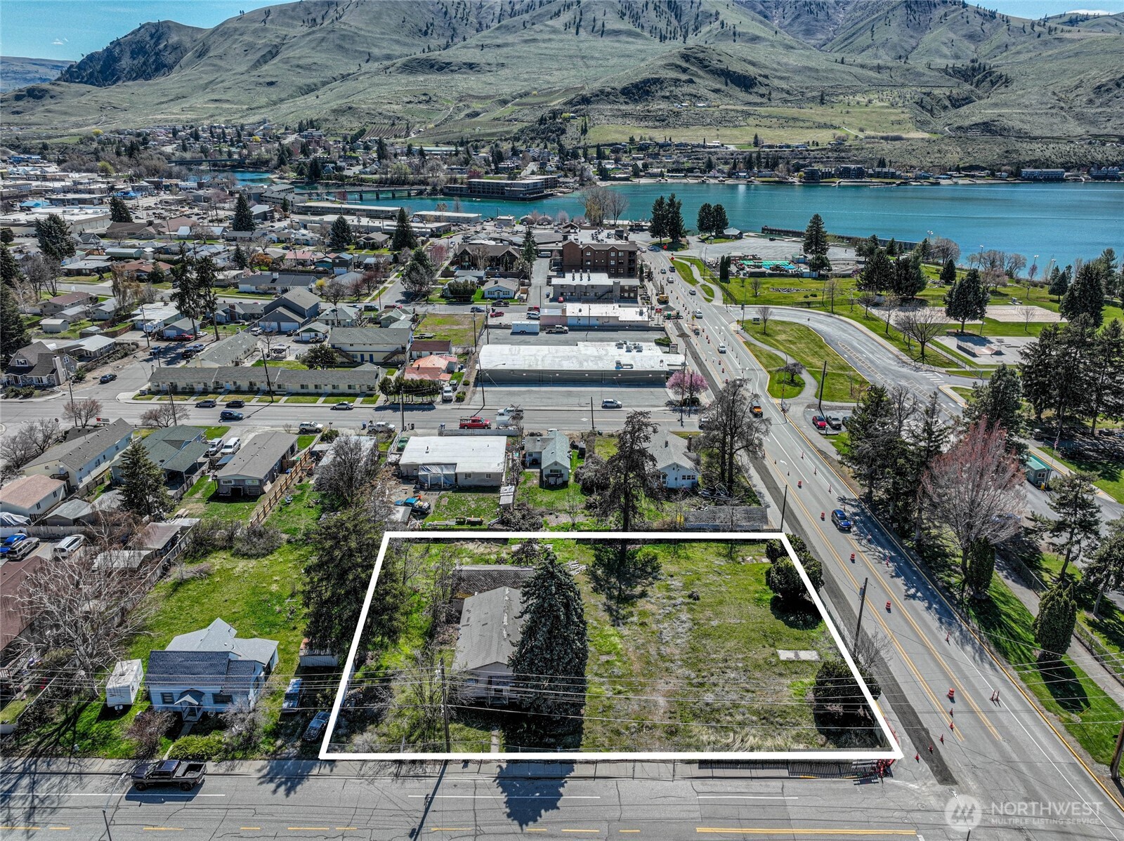 Aerial view of a white-outlined parcel near Lake Chelan, with the town and hills beyond.