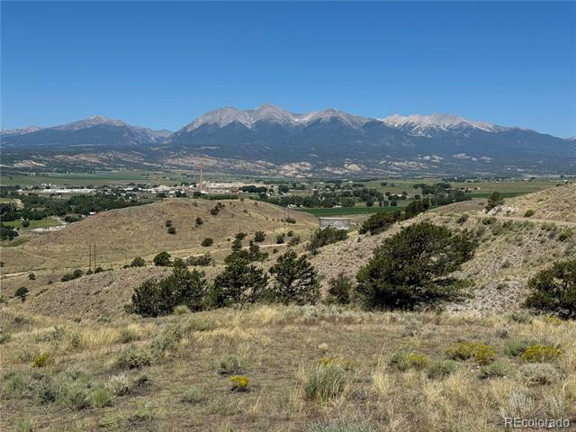 Mountain range beyond grassy foothills and a green valley.