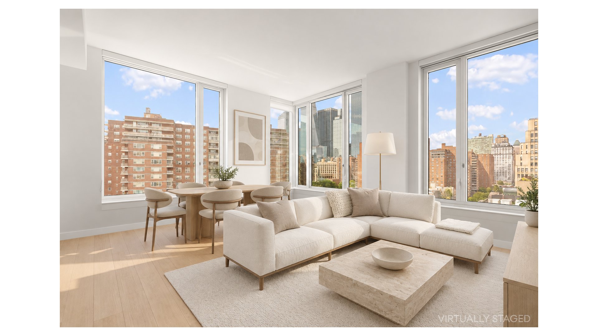 Staged apartment living room with a cream sectional and expansive city-view windows.