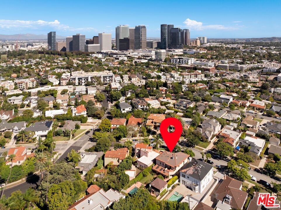 Aerial view of a Los Angeles neighborhood with a red pin and distant city skyline.