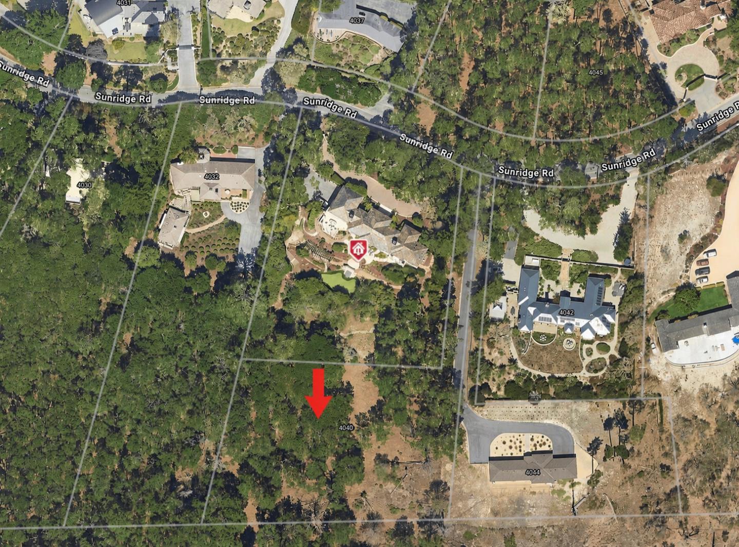 Aerial view of the wooded 4040 Sunridge Road parcel, marked by a red arrow among neighboring homes.