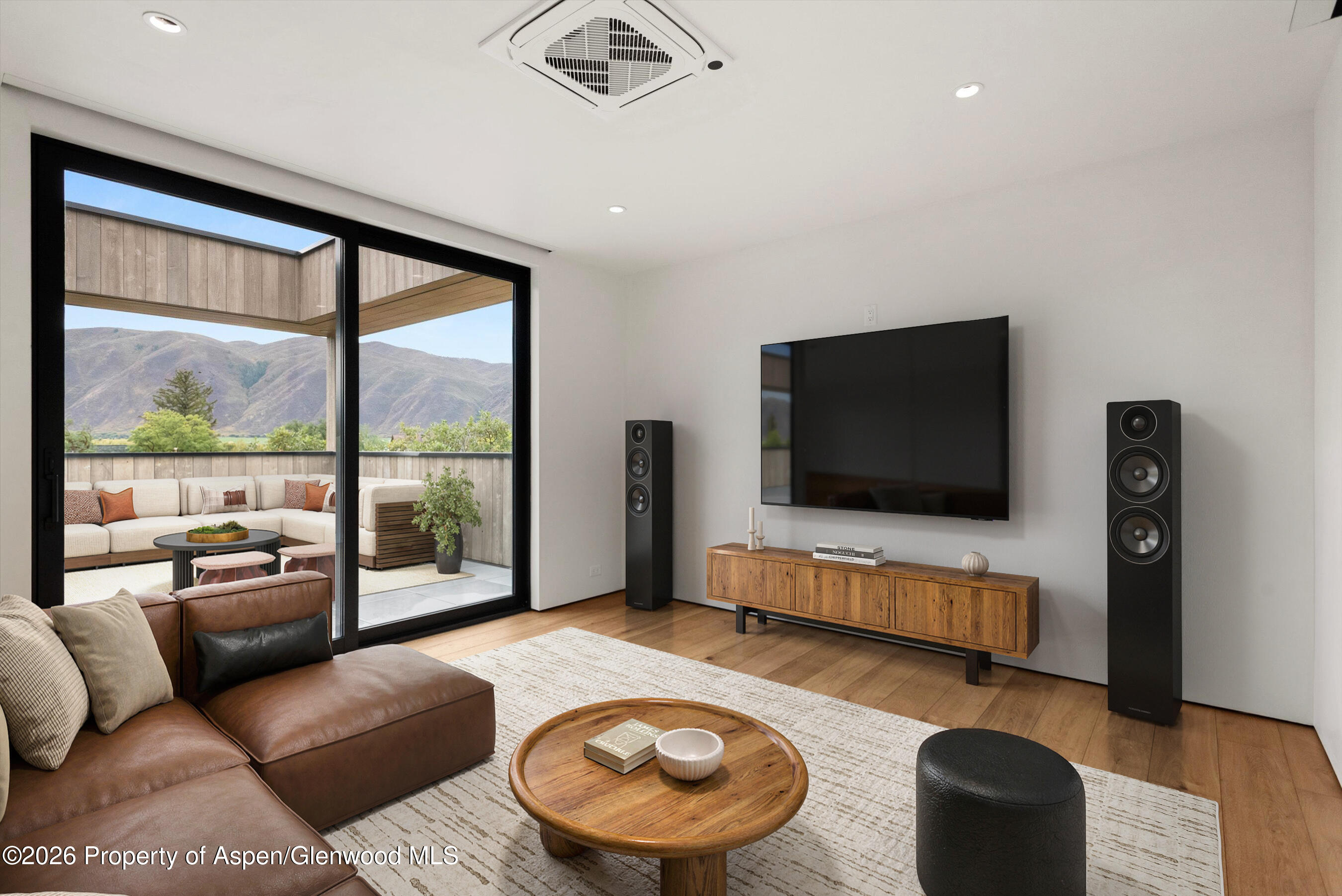 Contemporary living room with leather sectional, large sliding doors, and mountain views.