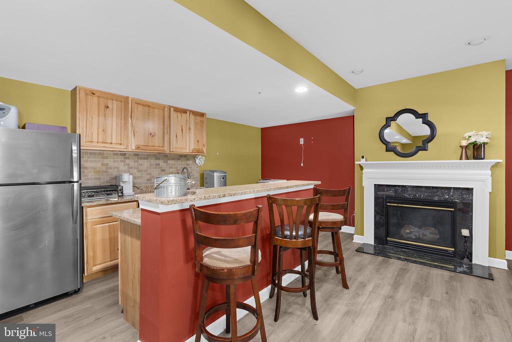 Kitchen with a red breakfast bar, natural wood cabinets, and a fireplace.