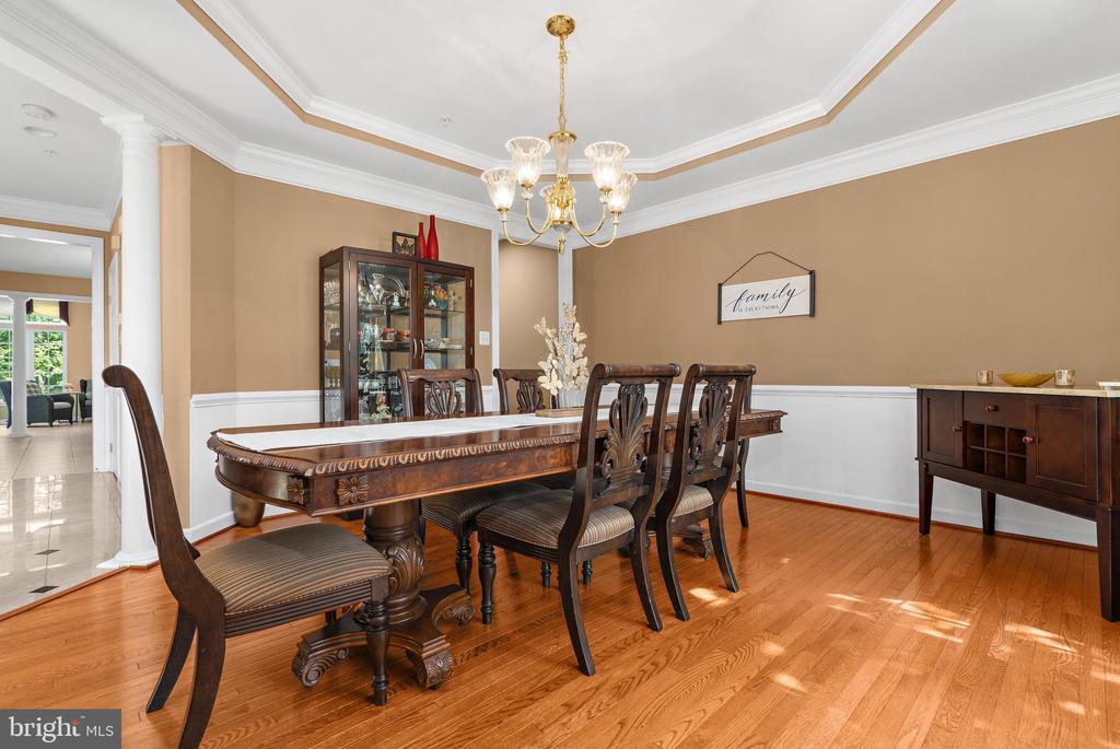 Dining room with a long dark wood table, matching chairs, and a glass-front display cabinet.