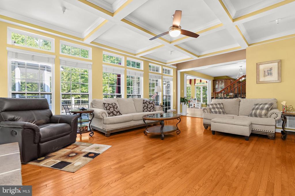 Living room with hardwood floors, large windows, and a white coffered ceiling.