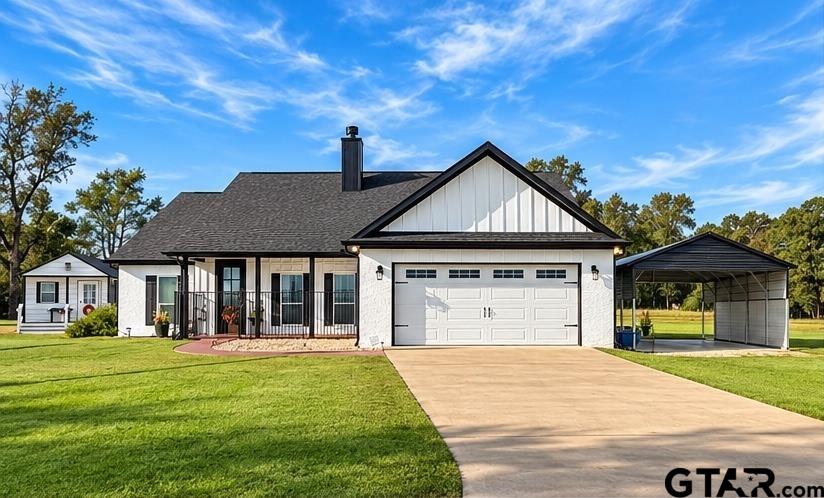 White house with a front-facing garage, covered carport, and broad green lawn.