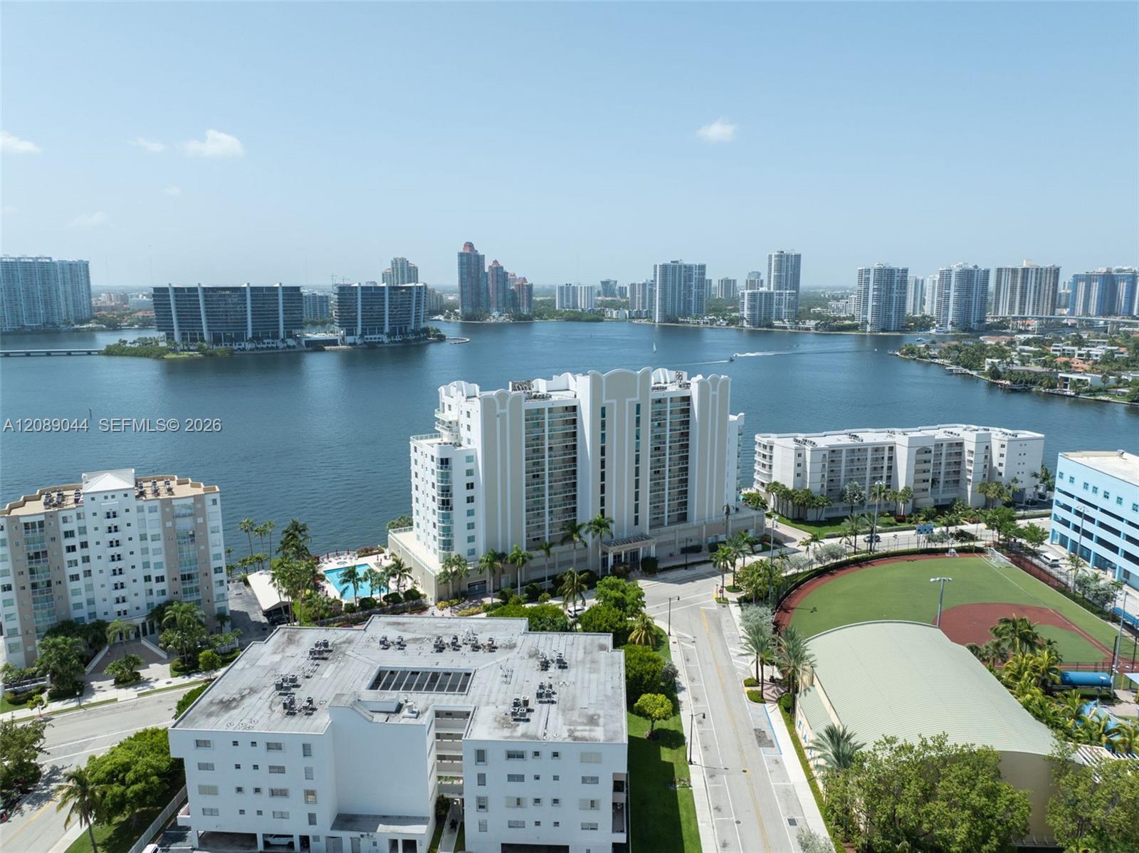 Aerial view of waterfront towers and a broad bay, with high-rises across the water.