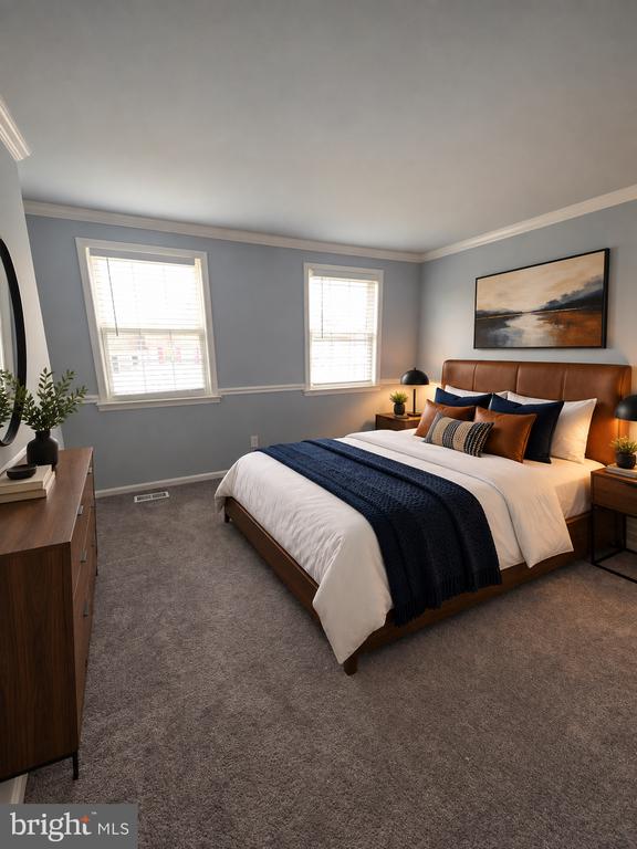 Furnished bedroom with a wooden bed, navy throw, gray walls, and two windows.