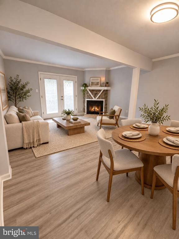 Open-plan living and dining room with a fireplace, round table, and light wood flooring.