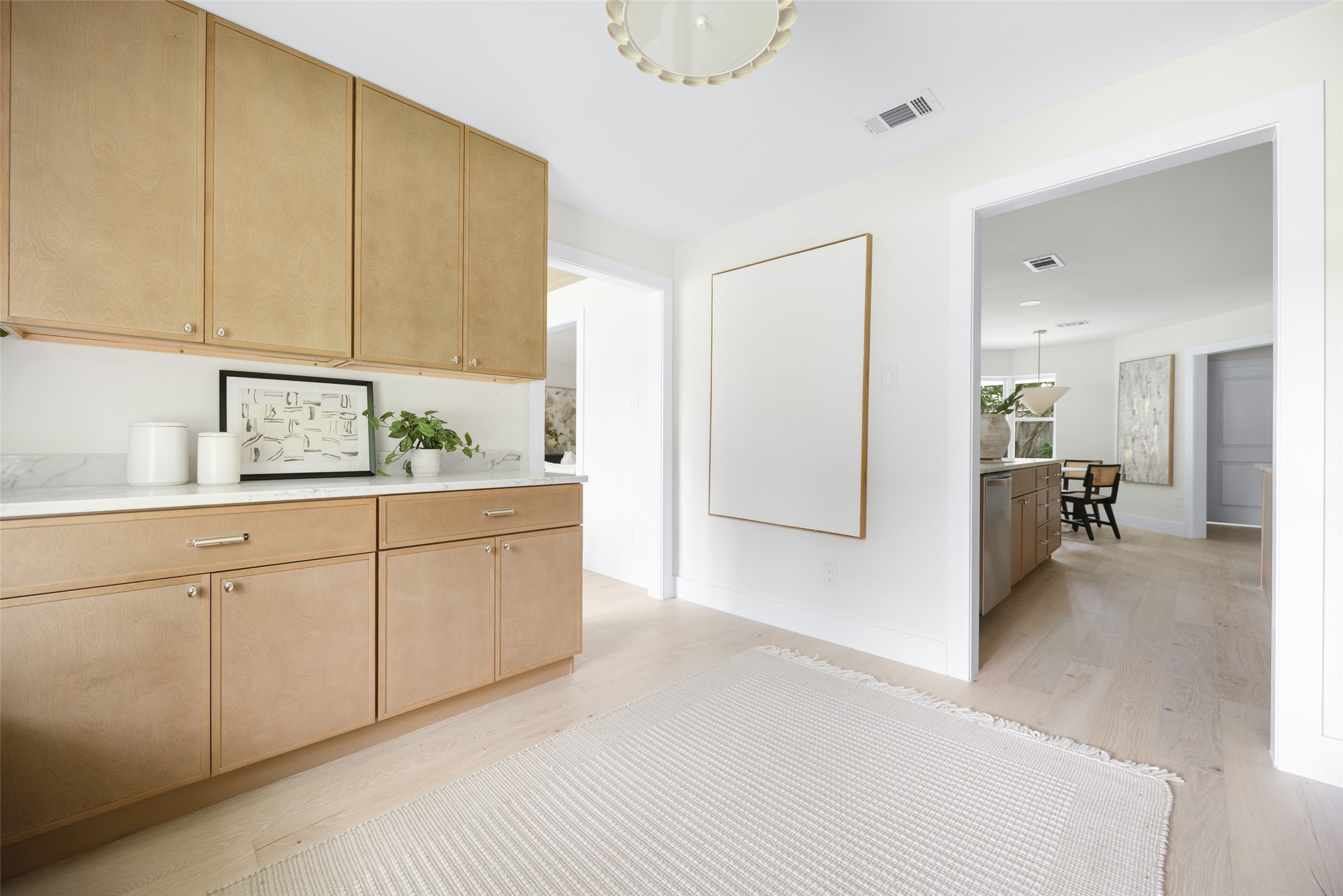 Kitchen with light oak cabinetry and a wide doorway to the dining area.