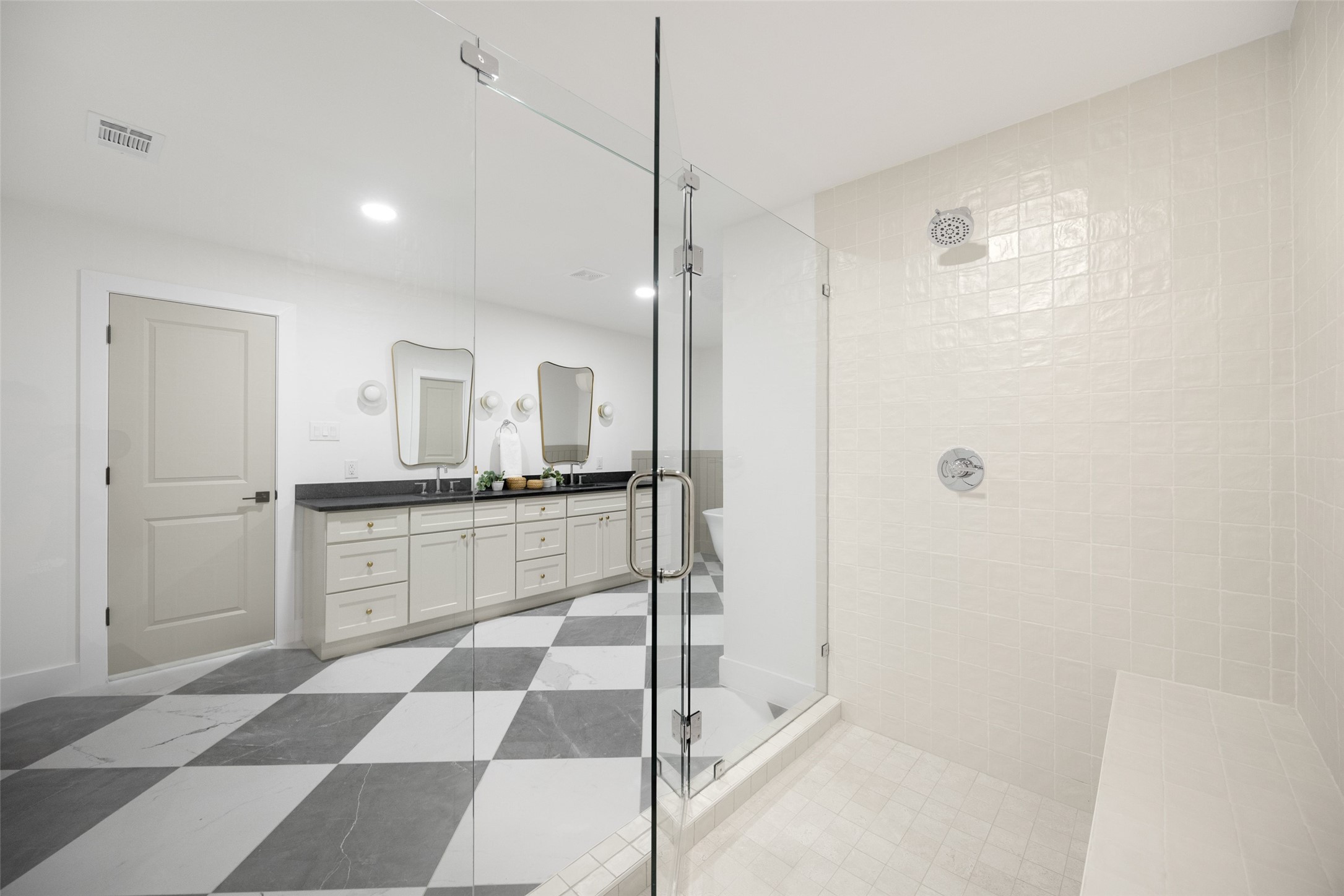 Bathroom with a glass walk-in shower, double vanity, and bold gray-and-white checkerboard floor.