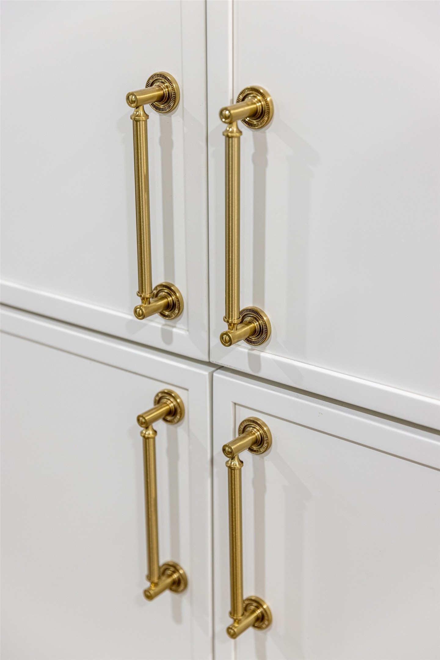 White paneled cabinets with ornate brass pull handles.