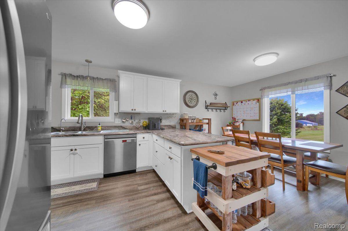 Kitchen with white cabinets, butcher-block island, and dining area beside sliding glass doors.