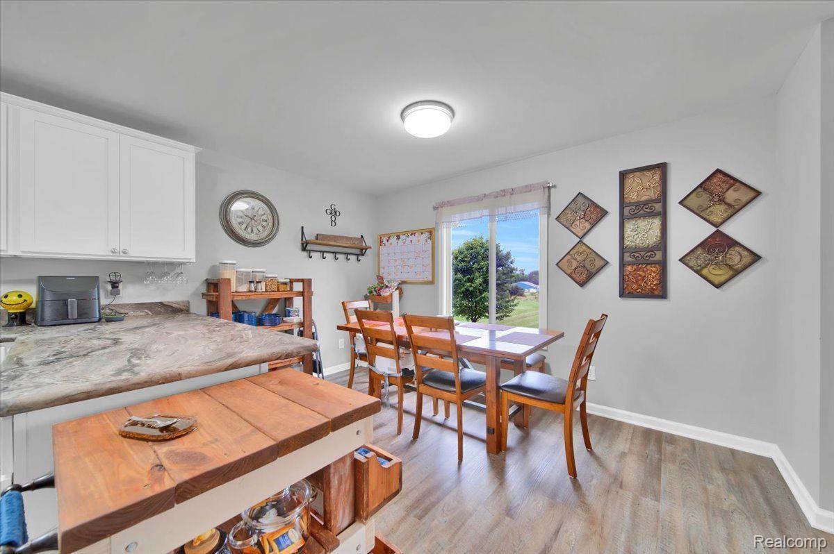 Kitchen and dining area with a butcher-block island and dining table beside a sliding glass door.