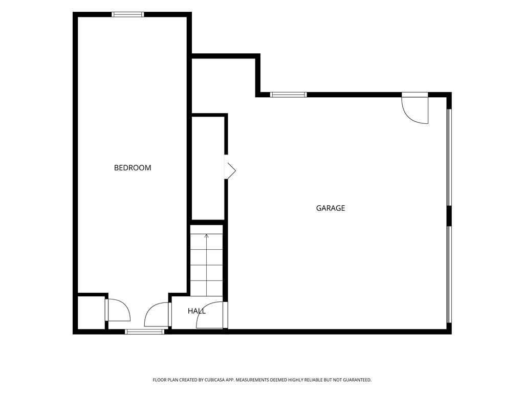 Floor plan showing a bedroom, garage, hall, and stairs.