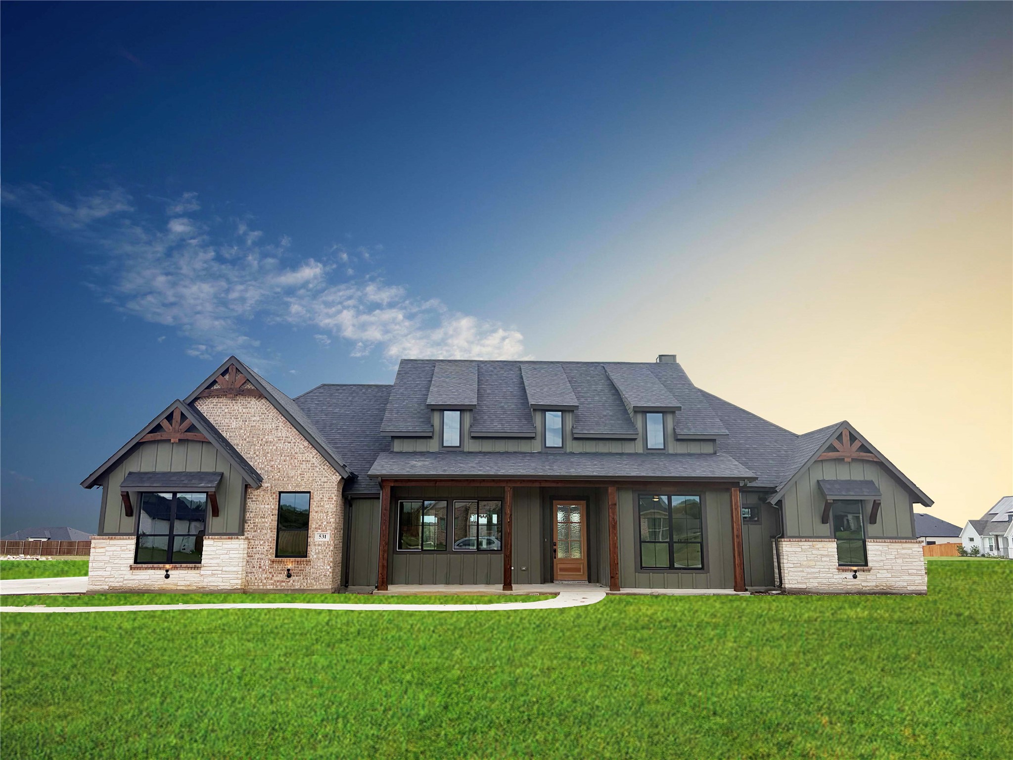 Detached home with multiple gables, brick and stone accents, and a broad green lawn.