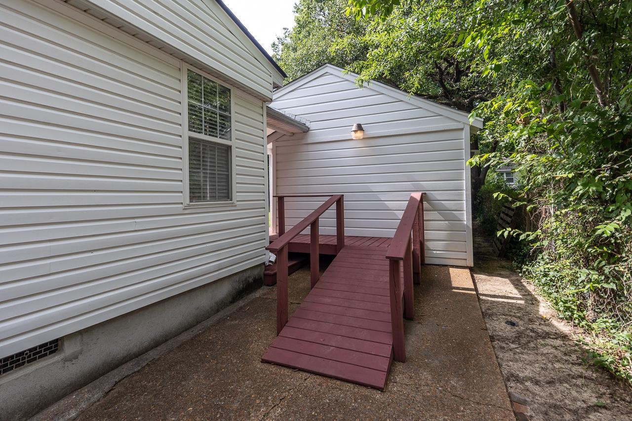 House exterior with a burgundy wooden access ramp leading to the entrance.