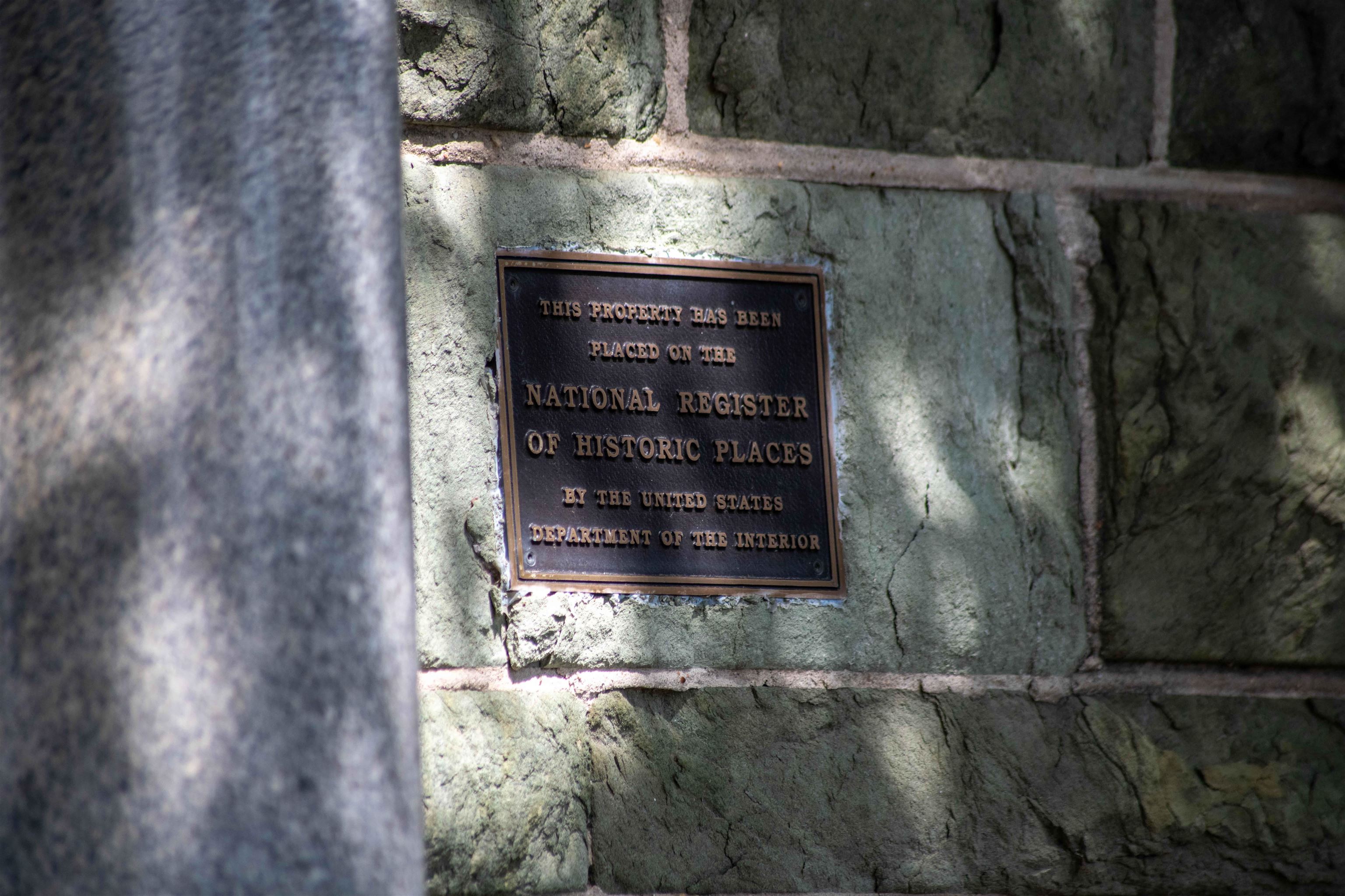 National Register of Historic Places plaque mounted on a stone wall.