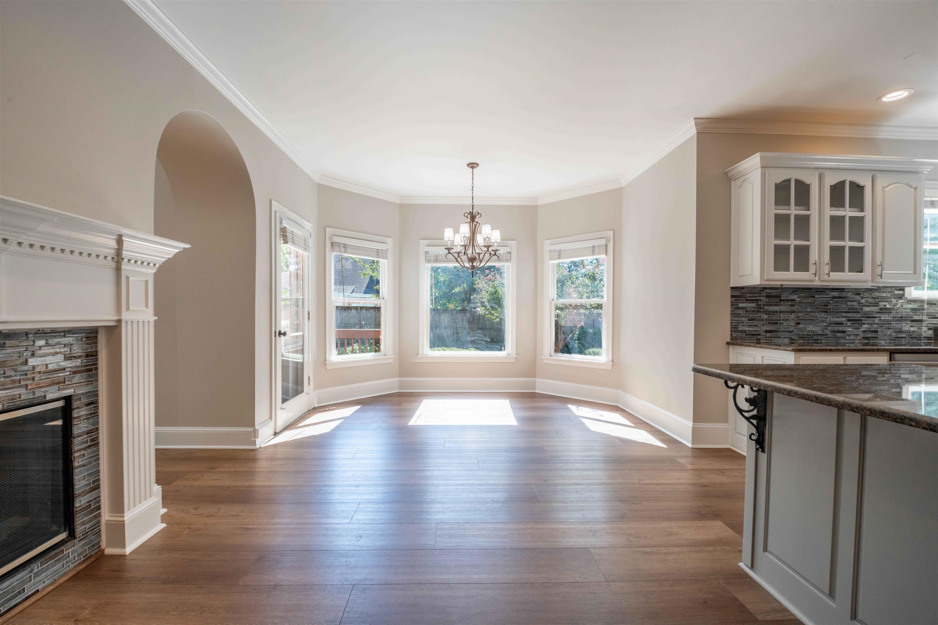 Dining area with bay windows, a fireplace, and an adjoining kitchen island.