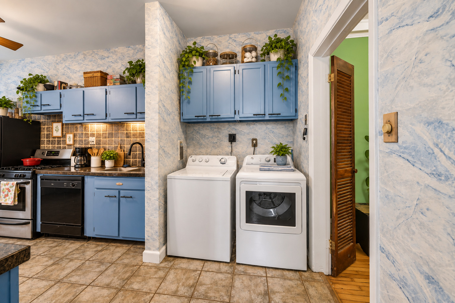 Kitchen and laundry area with blue cabinets and a white washer and dryer.
