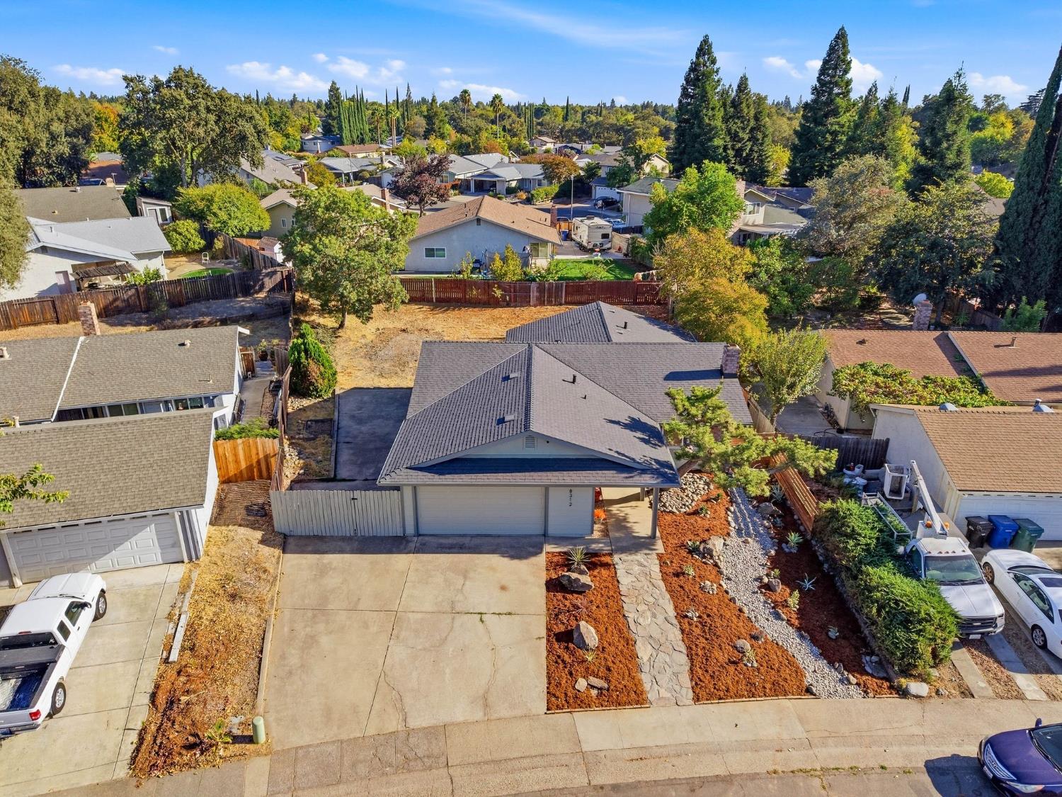Aerial view of a single-story home with a broad driveway and drought-tolerant front landscaping.