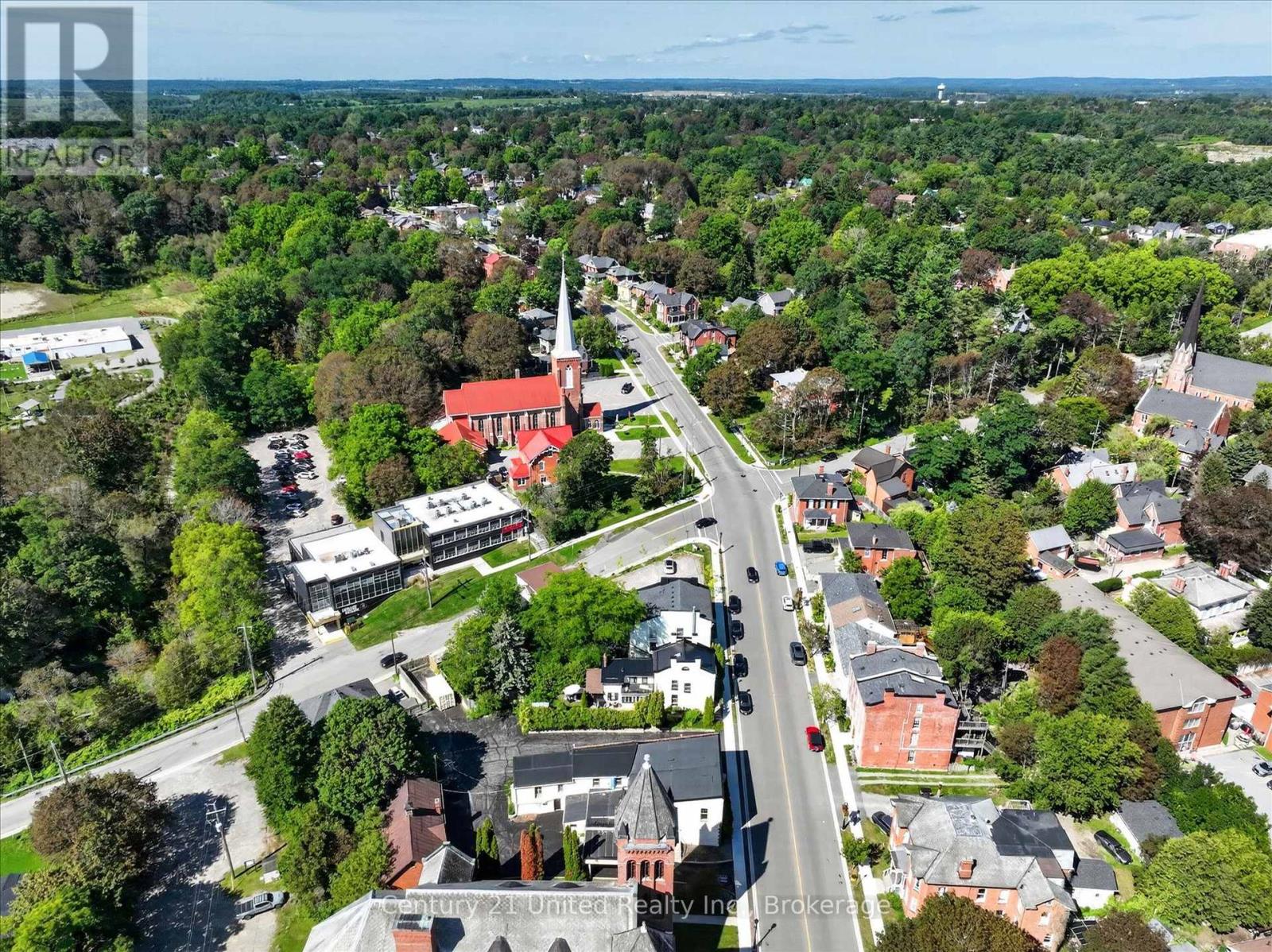 Aerial view of a leafy Port Hope neighborhood, with a main street and prominent church steeples.