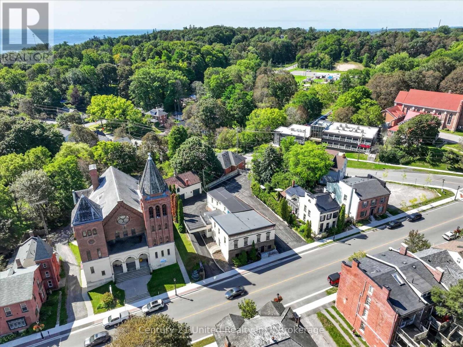 Aerial view of downtown Port Hope, with a historic church, Walton Street buildings, and water in the distance.
