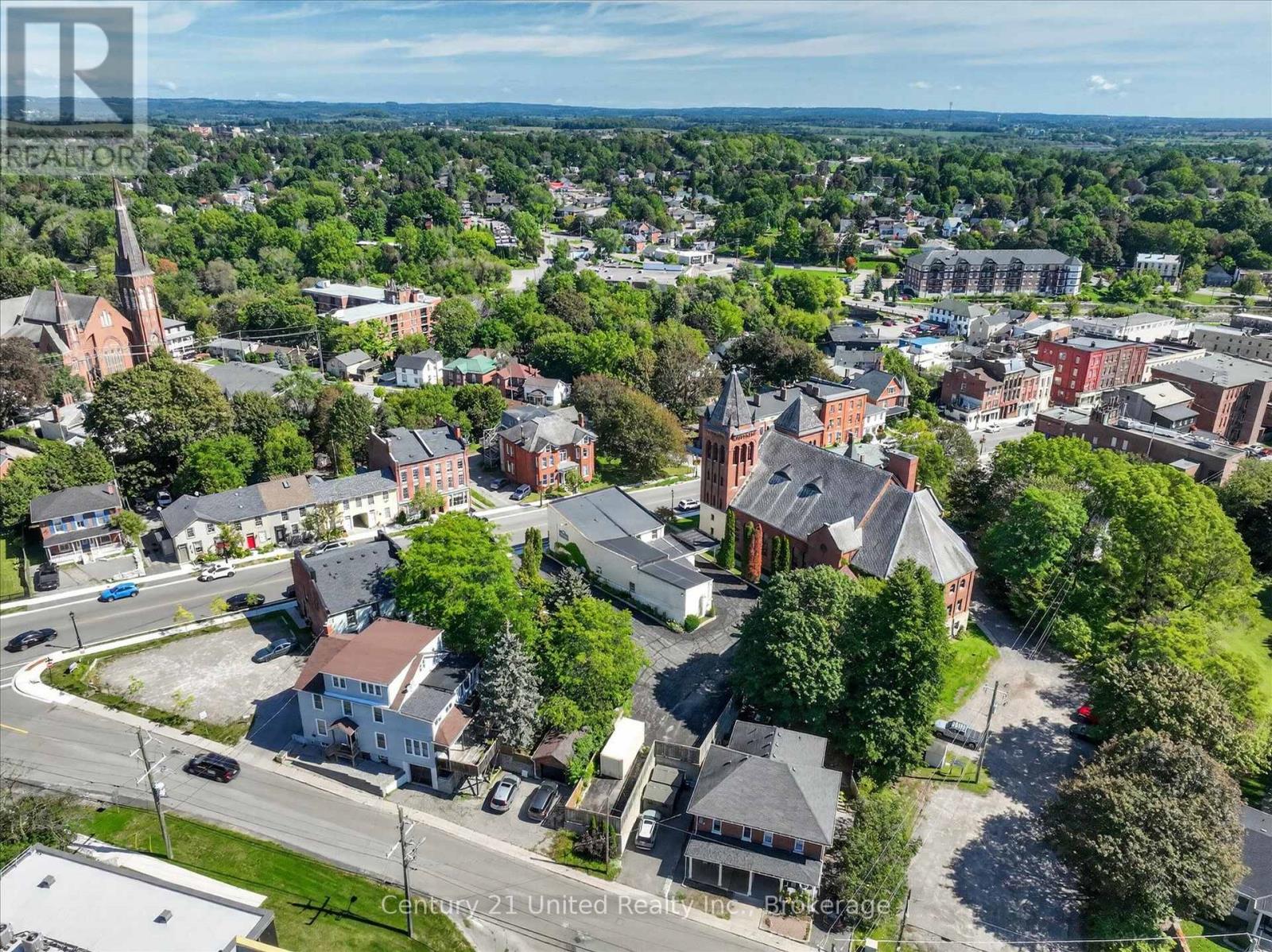 Aerial view of a leafy town center with church spires and surrounding homes and businesses.