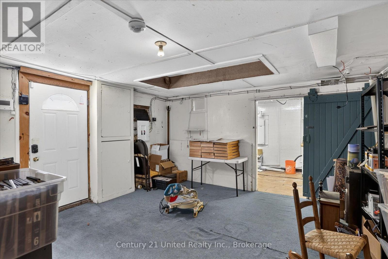 Garage storage area with a white entry door, folding table, and dark teal sliding barn door.