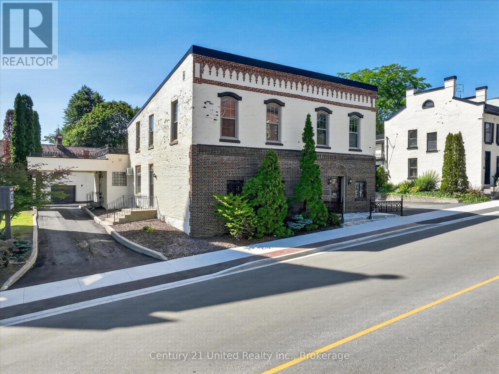 Two-storey brick building with arched windows and a decorative cornice on Walton Street.