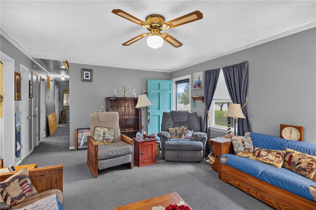 Living room with a turquoise door, blue sofa, gray recliners, and wooden ceiling fan.