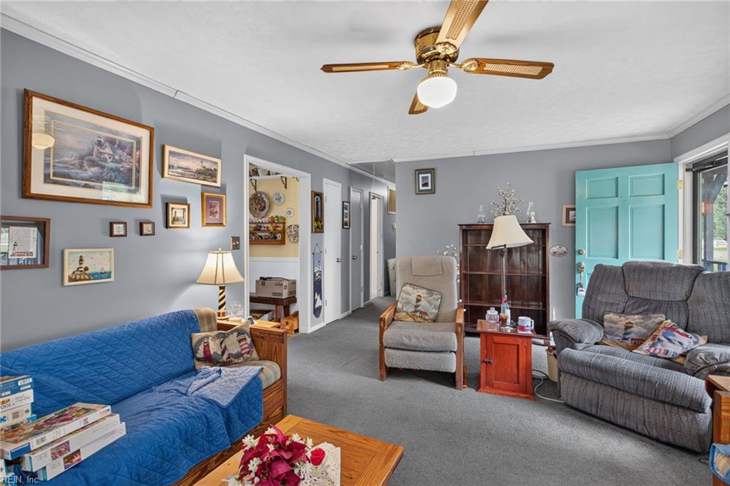 Furnished living room with a blue-covered sofa, gray seating, and an open turquoise door.