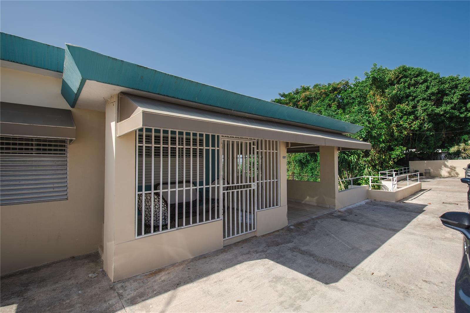 Single-story property with barred windows, a covered patio, and a concrete driveway.