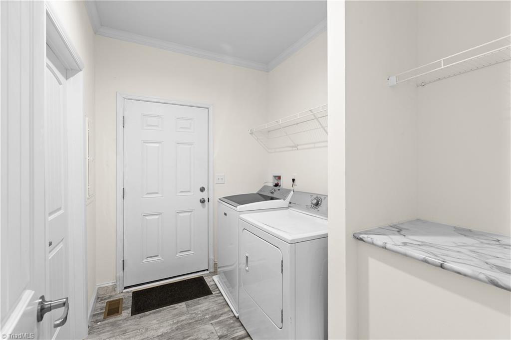 Laundry room with white washer and dryer, wire shelves, and a marble-look folding counter.