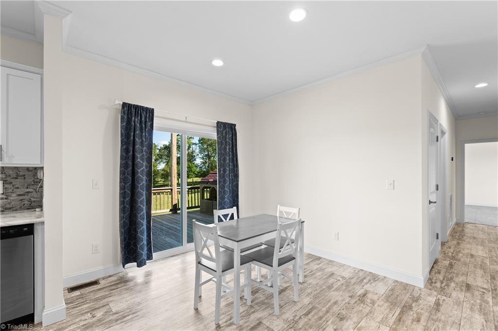 Dining area with a gray table beside sliding doors opening to a deck.