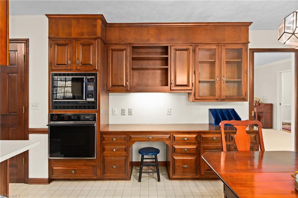 Kitchen with extensive wood cabinetry, built-in microwave and oven, and a desk nook.