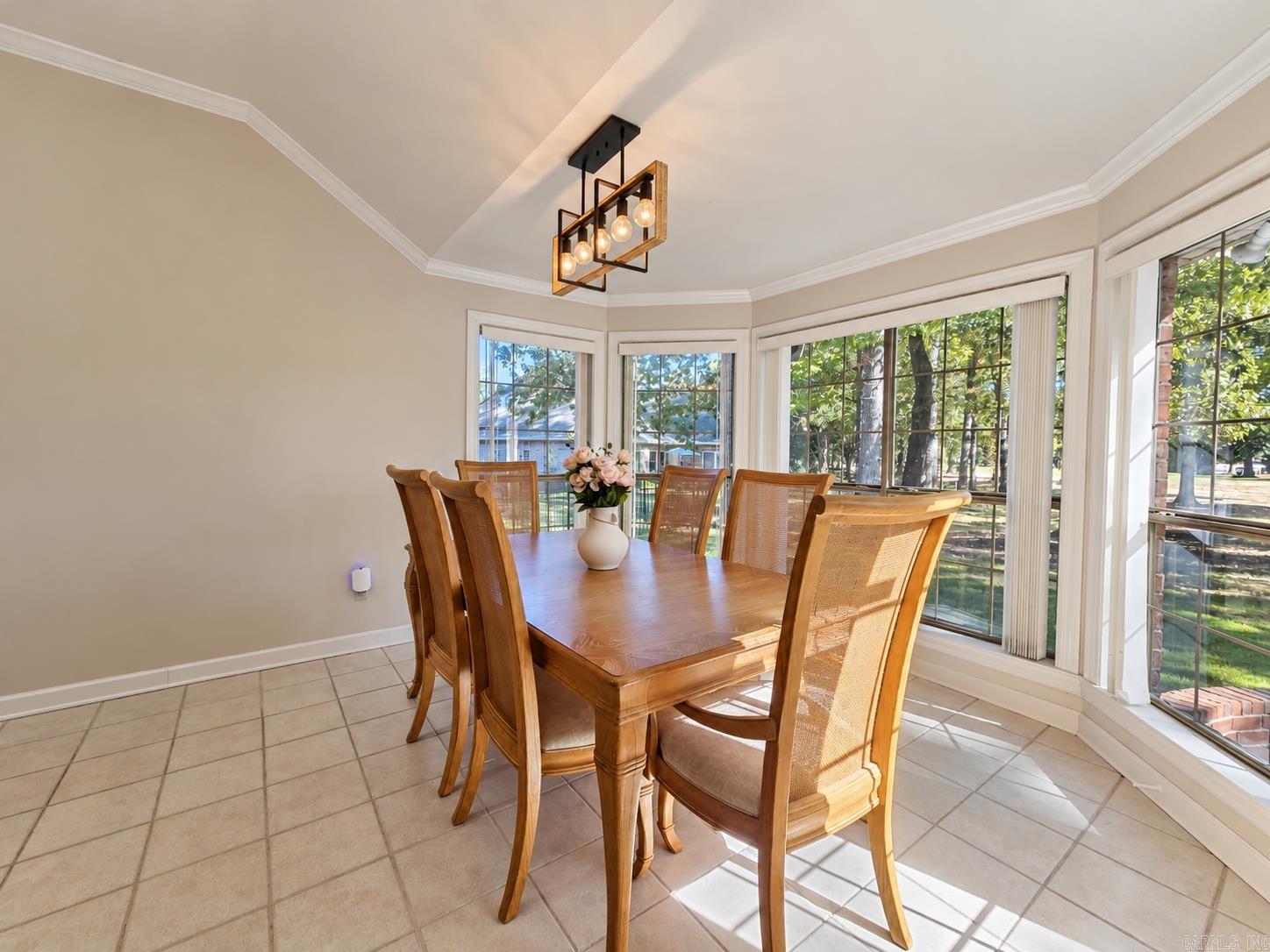 Dining room with a wooden table and chairs, large windows, and a geometric pendant light.