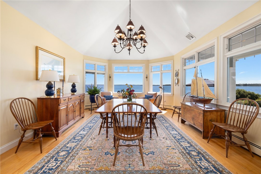 Furnished dining room with a large table and wide windows overlooking the water.