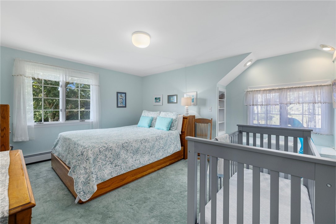 Bedroom with a wooden bed, pale blue walls, and gray railing around an open stairwell.