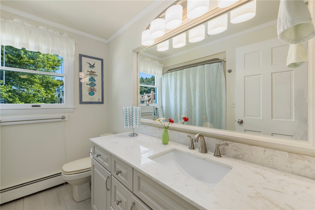 Bright bathroom with a white double vanity, large mirror, and curtained tub.