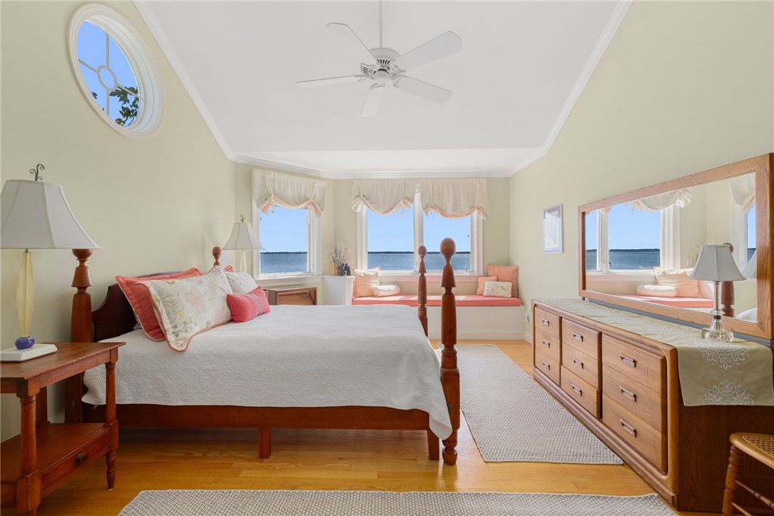 Bedroom with a four-poster bed, window seat, and water views.
