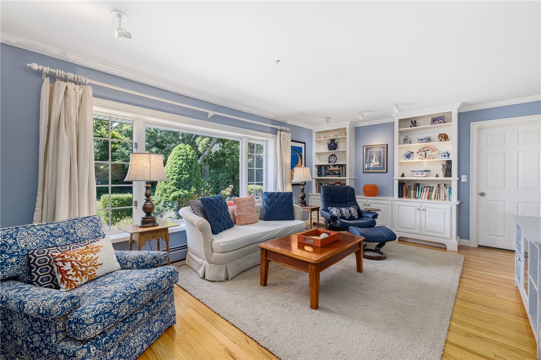 Living room with blue walls, built-in shelves, large windows, and patterned seating.