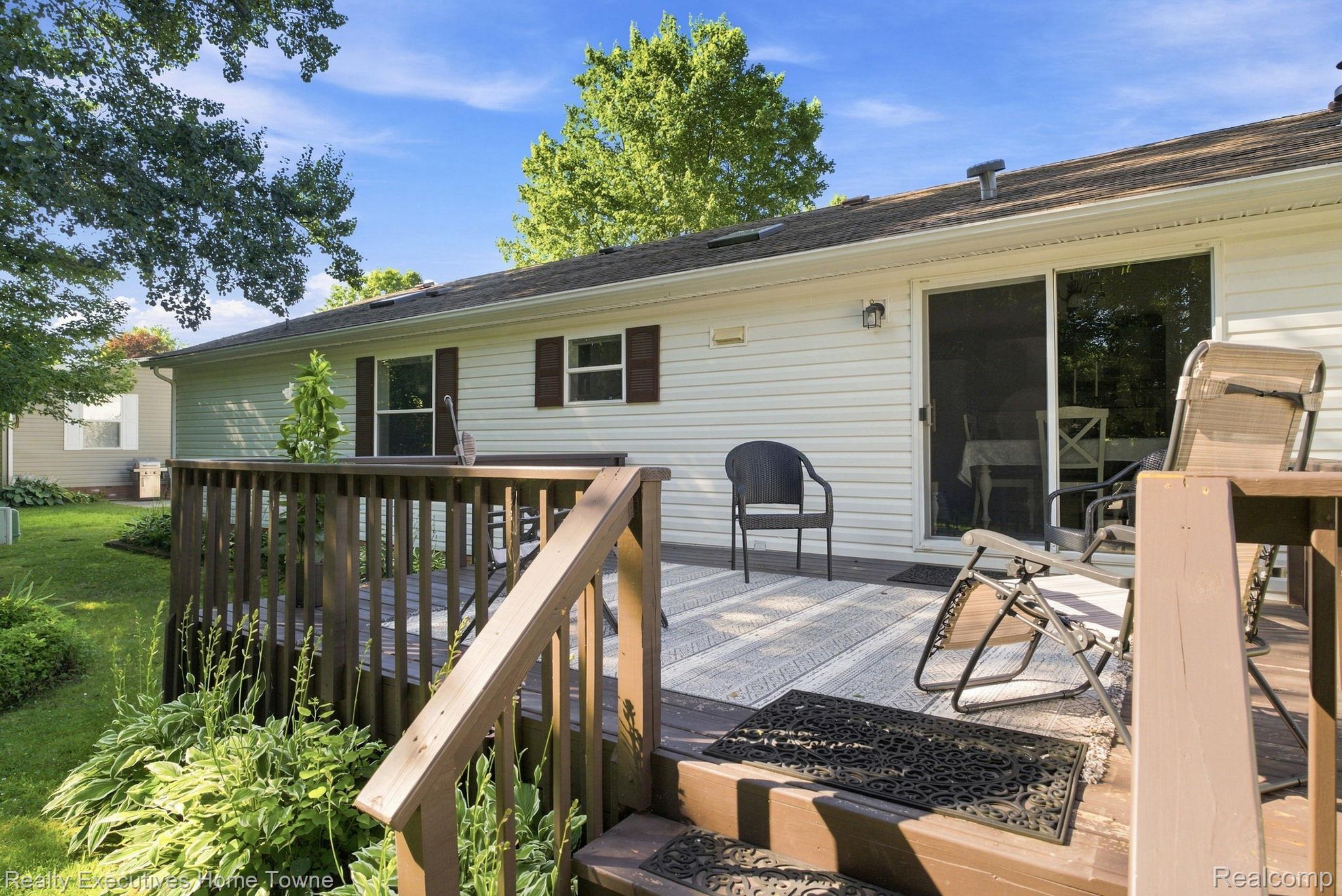 Raised wooden deck with patio seating beside the home's sliding glass doors.