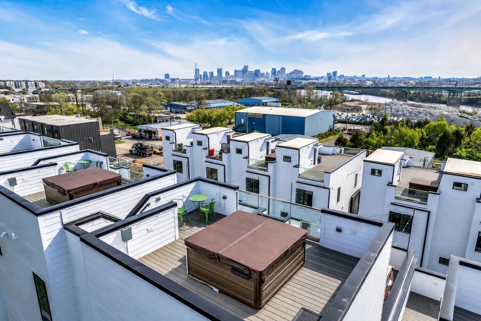 Modern townhome rooftops with hot tubs and decks overlook the Nashville skyline.