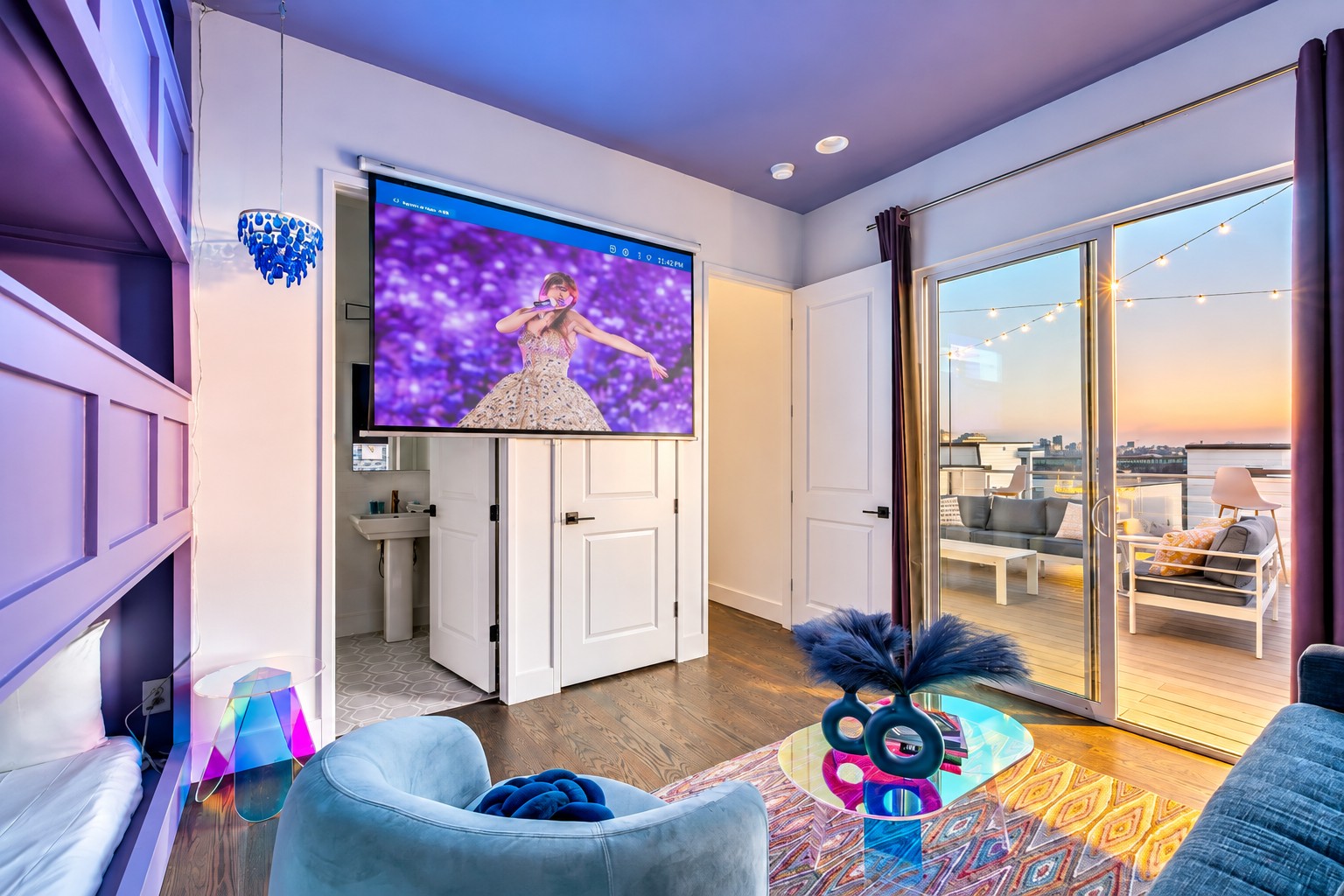Furnished living room with colorful decor and sliding doors opening onto a sunset-lit balcony.