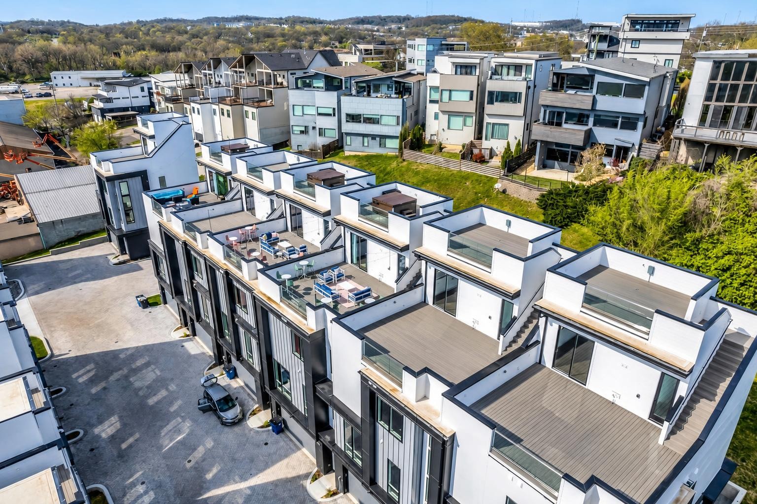 Aerial view of modern townhomes with rooftop terraces and a shared courtyard