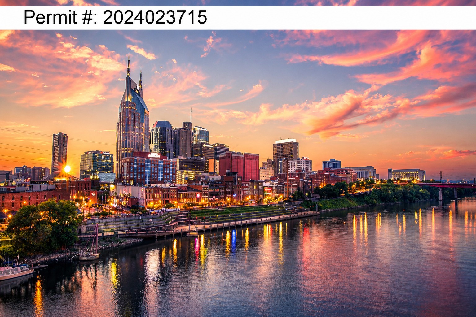Nashville skyline at sunset above the Cumberland River, with colorful lights reflected in the water.